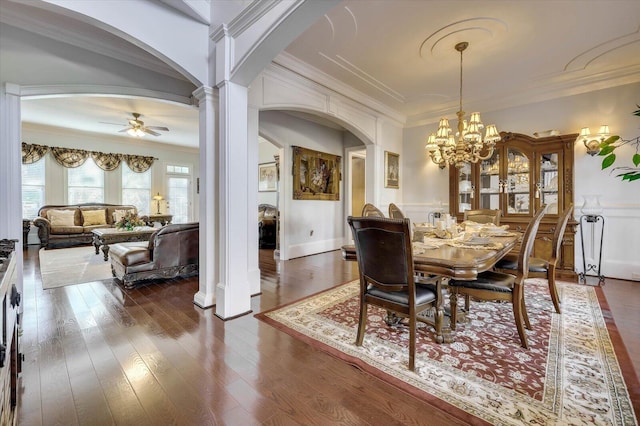 dining area featuring ceiling fan with notable chandelier, dark hardwood / wood-style flooring, ornamental molding, and decorative columns