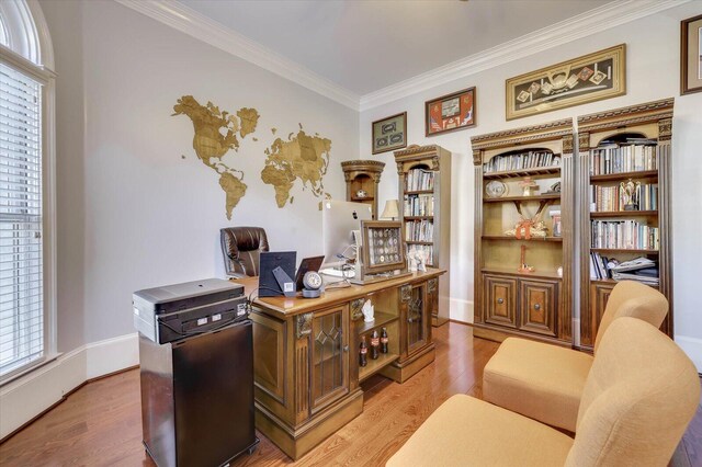 office space with light wood-type flooring and ornamental molding