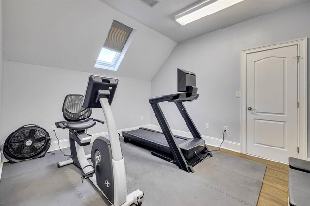 workout room featuring wood-type flooring and vaulted ceiling