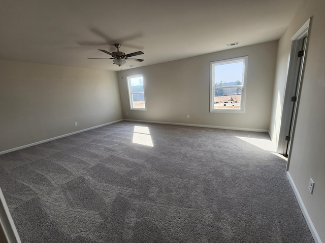 unfurnished room with dark colored carpet and ceiling fan