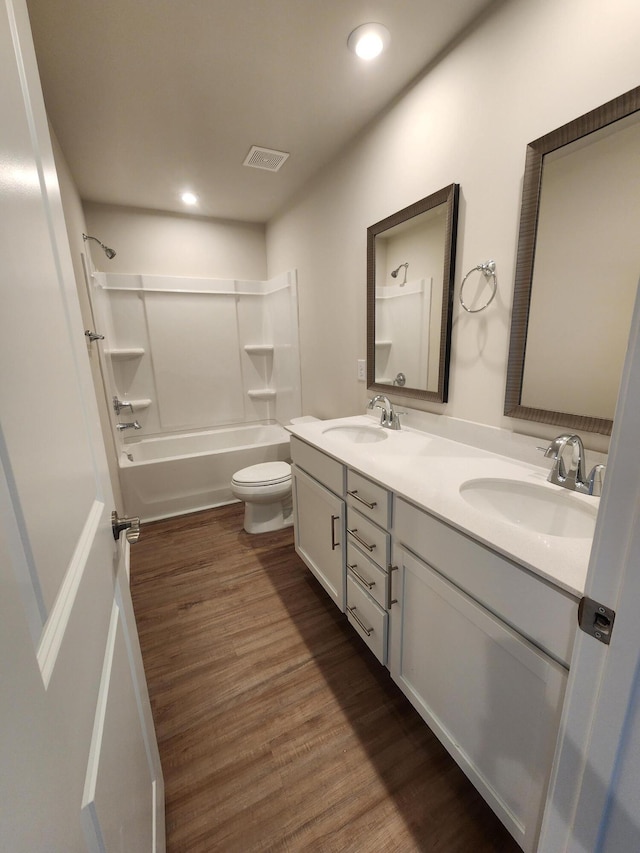 full bathroom with vanity, bathtub / shower combination, hardwood / wood-style floors, and toilet