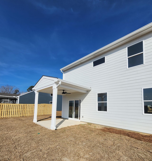 rear view of property with a lawn, ceiling fan, and a patio area