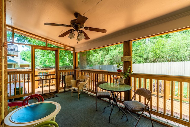 sunroom featuring ceiling fan, a healthy amount of sunlight, and vaulted ceiling