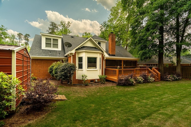 back of property featuring a deck and a lawn