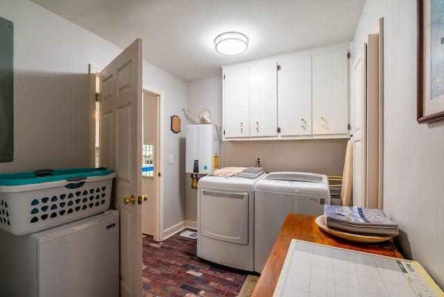 laundry room with tankless water heater, independent washer and dryer, and cabinets