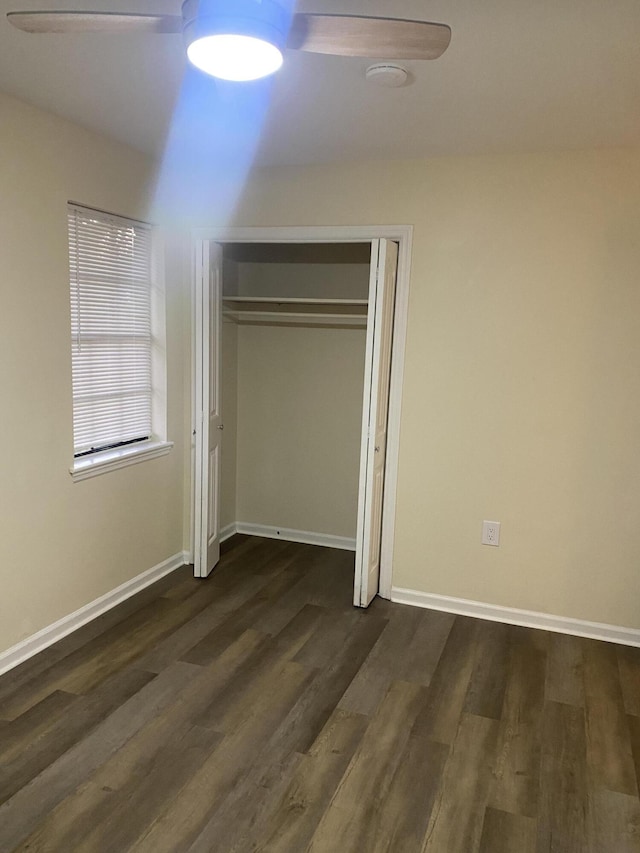 unfurnished bedroom with ceiling fan, a closet, and dark hardwood / wood-style floors