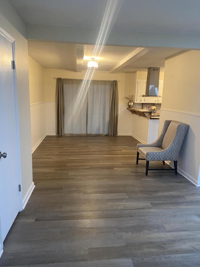 unfurnished room featuring beamed ceiling and dark wood-type flooring