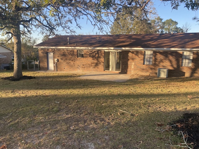 back of house featuring a lawn and a patio