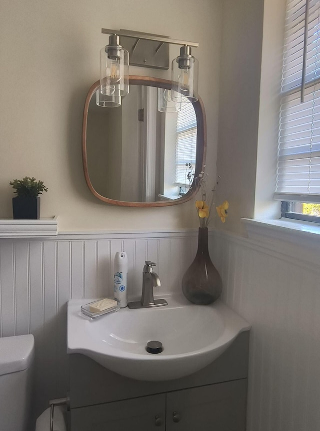 bathroom with plenty of natural light, vanity, and toilet