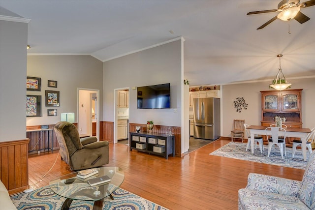 living room featuring ceiling fan, lofted ceiling, light hardwood / wood-style flooring, and ornamental molding