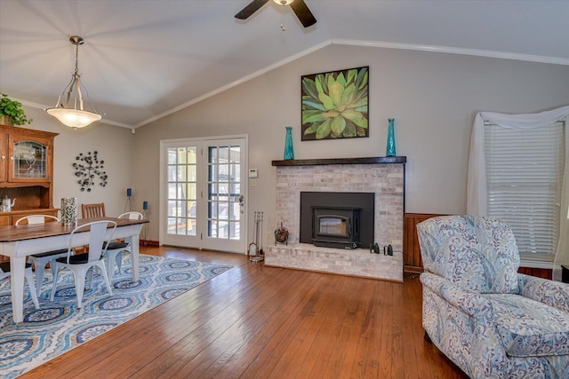 living room with ornamental molding, lofted ceiling, and hardwood / wood-style floors