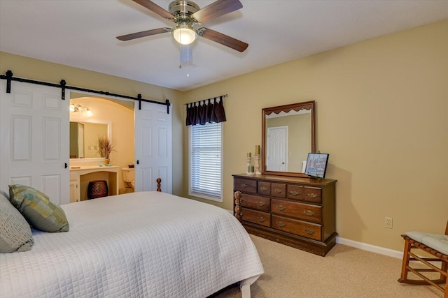 carpeted bedroom featuring ceiling fan, a barn door, and connected bathroom