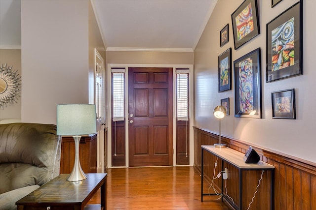 entryway featuring lofted ceiling, crown molding, and light hardwood / wood-style floors