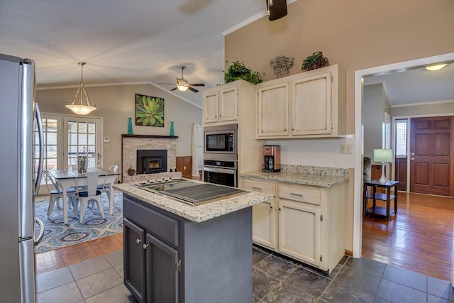 kitchen featuring a kitchen island, pendant lighting, a wealth of natural light, appliances with stainless steel finishes, and gray cabinetry