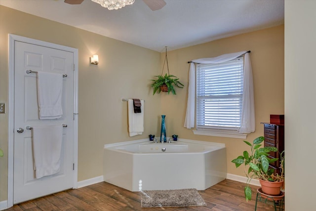 bathroom featuring hardwood / wood-style flooring, a tub, and ceiling fan