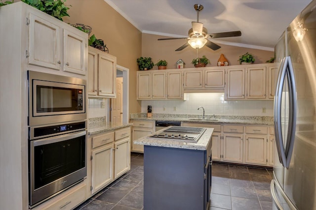 kitchen featuring stainless steel appliances, a center island, vaulted ceiling, light stone counters, and sink