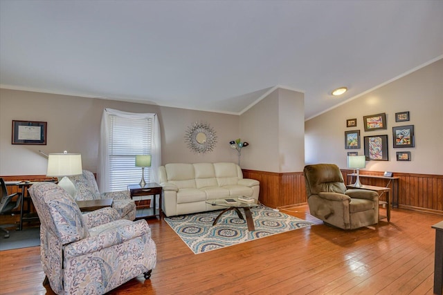 living room with hardwood / wood-style flooring, lofted ceiling, and ornamental molding