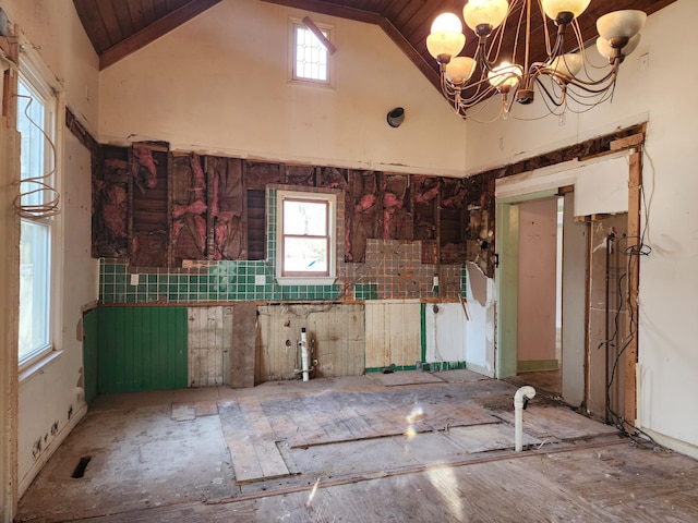 interior space with plenty of natural light, high vaulted ceiling, and a notable chandelier