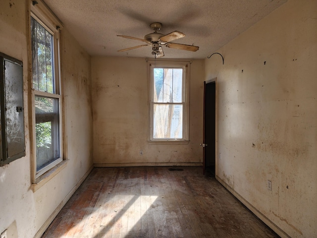 empty room featuring ceiling fan, wood-type flooring, and a textured ceiling