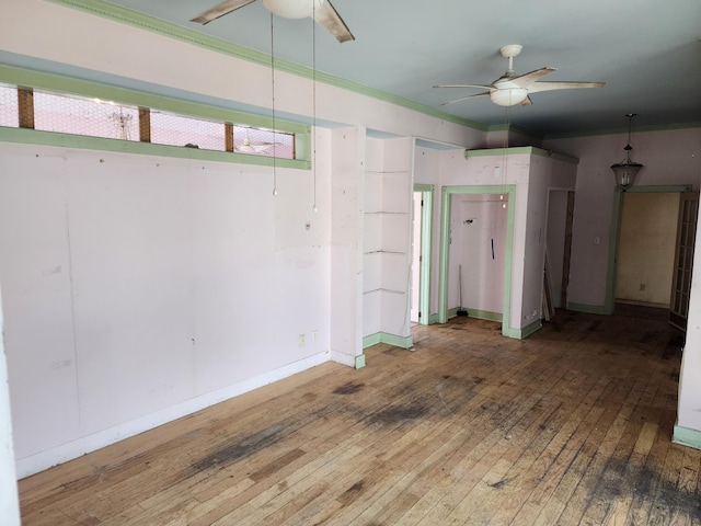 empty room with hardwood / wood-style floors, ornamental molding, and ceiling fan