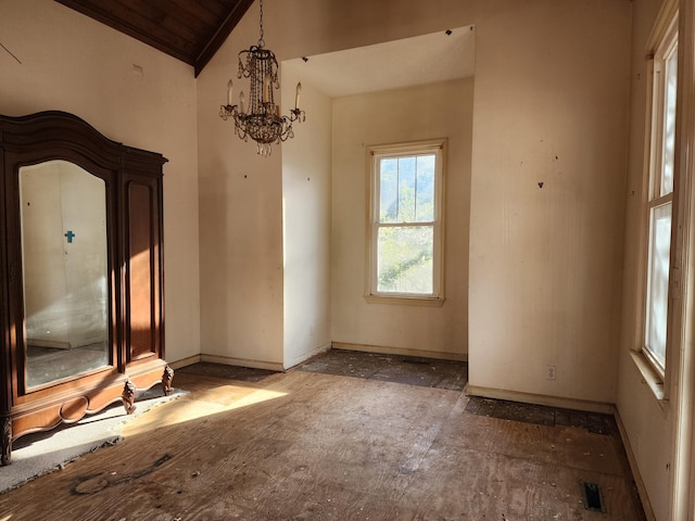 empty room featuring lofted ceiling and a notable chandelier