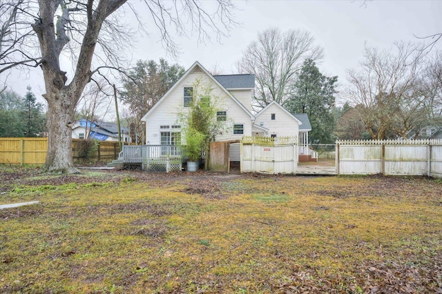 rear view of property with a deck and a lawn