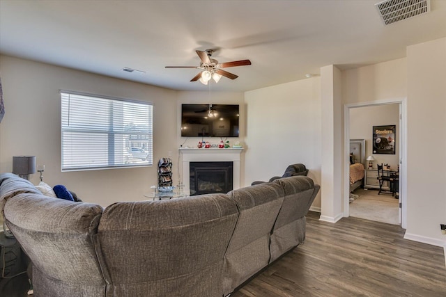 living room featuring ceiling fan and dark hardwood / wood-style floors