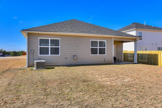 rear view of property with a yard and cooling unit