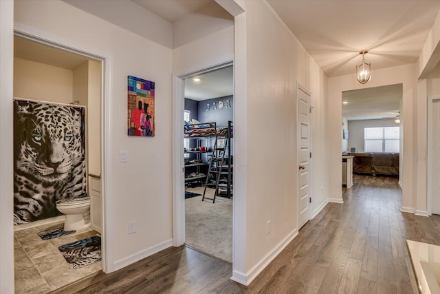 hall featuring an inviting chandelier and hardwood / wood-style flooring