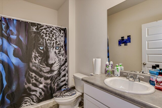 bathroom featuring walk in shower, vanity, and toilet