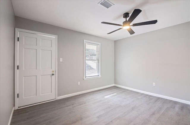 empty room with hardwood / wood-style flooring and ceiling fan