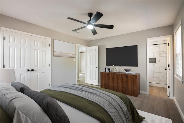 bedroom with hardwood / wood-style flooring, a closet, ceiling fan, and ensuite bathroom