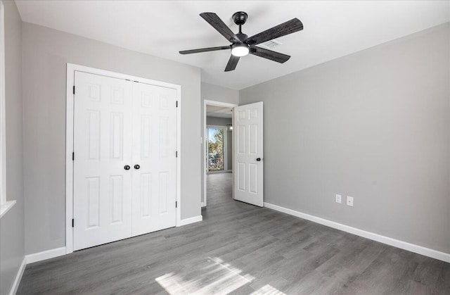 unfurnished bedroom featuring ceiling fan, wood-type flooring, and a closet