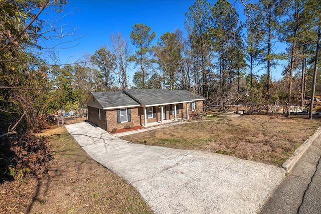 ranch-style home featuring a front lawn and covered porch