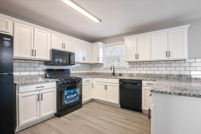 kitchen with black appliances, light hardwood / wood-style floors, and white cabinets