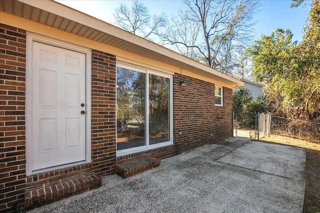 view of exterior entry with a patio