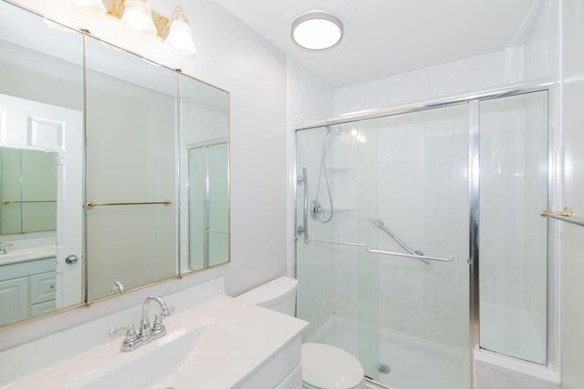 bathroom featuring vanity, toilet, and a shower with shower door