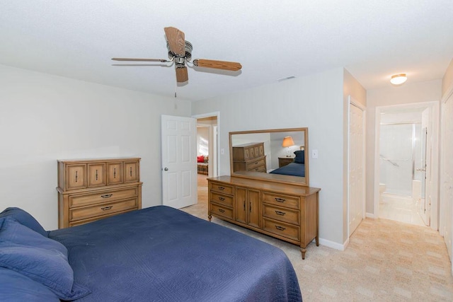 bedroom featuring ceiling fan, light carpet, and connected bathroom