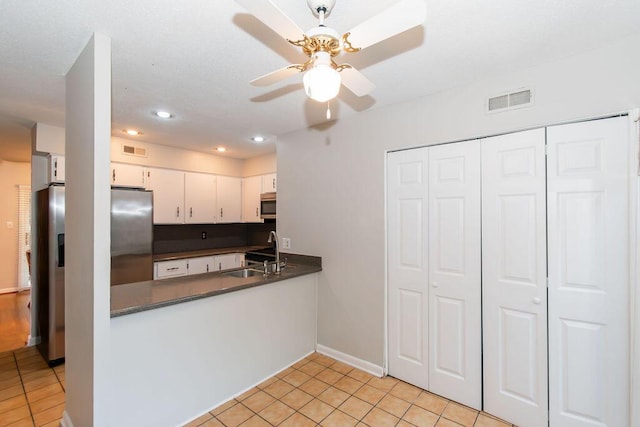 kitchen featuring white cabinetry, sink, light tile patterned flooring, and stainless steel appliances