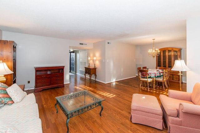 living room with dark hardwood / wood-style floors and a notable chandelier