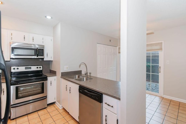 kitchen with sink, white cabinetry, stainless steel appliances, and light tile patterned floors