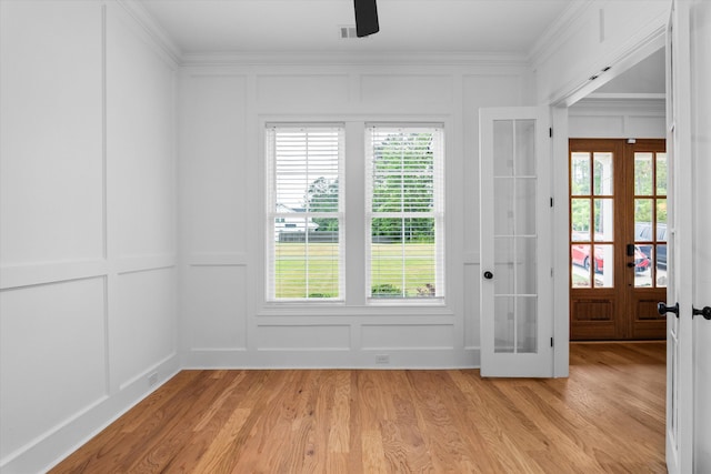 552 River Oaks Ln, Evans, GA 30809 - empty room with a decorative wall, french doors, ornamental molding, healthy amount of natural light, and light wood-type flooring