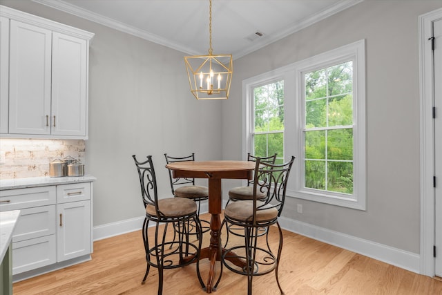 552 River Oaks Ln, Evans, GA 30809 - dining area with ornamental molding, light wood-style floors, a chandelier, and baseboards