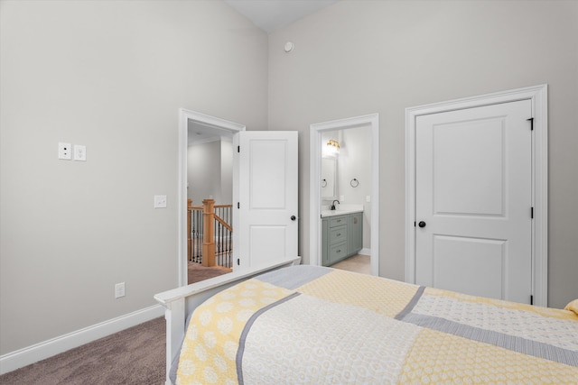 552 River Oaks Ln, Evans, GA 30809 - bedroom with high vaulted ceiling, baseboards, a sink, light colored carpet, and connected bathroom