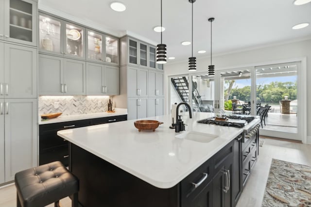 29 Savannah River Pl, North Augusta, SC 29841 - kitchen with backsplash, pendant lighting, a center island with sink, a sink, and light countertops