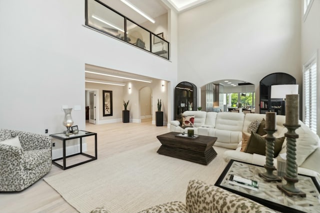 29 Savannah River Pl, North Augusta, SC 29841 - living room featuring baseboards, arched walkways, a high ceiling, and wood finished floors