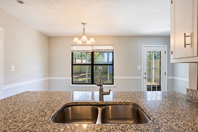 661 Kemper Dr, Evans, GA 30809 - kitchen with dark stone counters, healthy amount of natural light, a chandelier, and pendant lighting