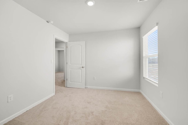 unfurnished room featuring light colored carpet