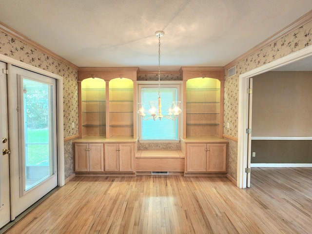 2023 Pisgah Rd, North Augusta, SC 29841 - unfurnished dining area with wallpapered walls, crown molding, light wood-type flooring, a chandelier, and healthy amount of natural light