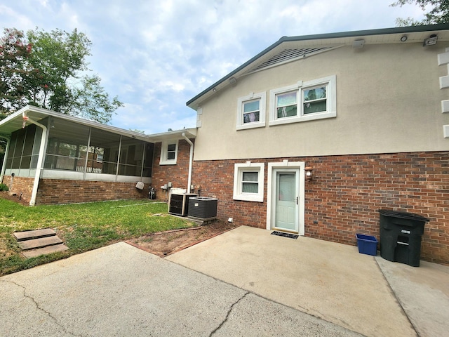 2023 Pisgah Rd, North Augusta, SC 29841 - rear view of house with a sunroom, a patio, a lawn, and stucco siding
